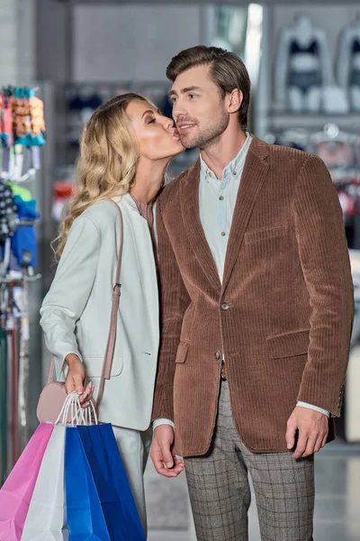 Young Woman Holding Shopping Bags Kissing Man Boutique — Stock Photo, Image