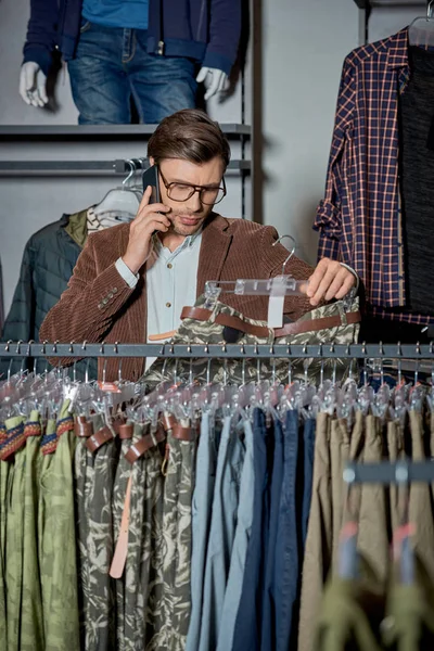 Man Eyeglasses Talking Smartphone Choosing Fashionable Clothes Shop — Free Stock Photo