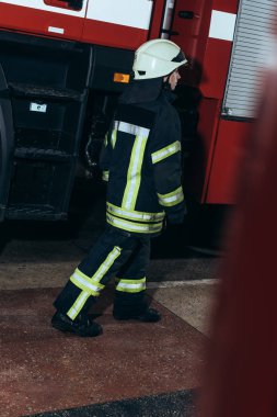 Yangın İstasyonu üniformalı kadın itfaiyeci ve kask, yürüyüş