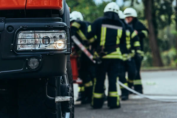 Επιλεκτική Εστίαση Της Πυροσβέστες Ταξιαρχίας Στέκεται Στο Πυροσβεστικό Όχημα Στον — Φωτογραφία Αρχείου