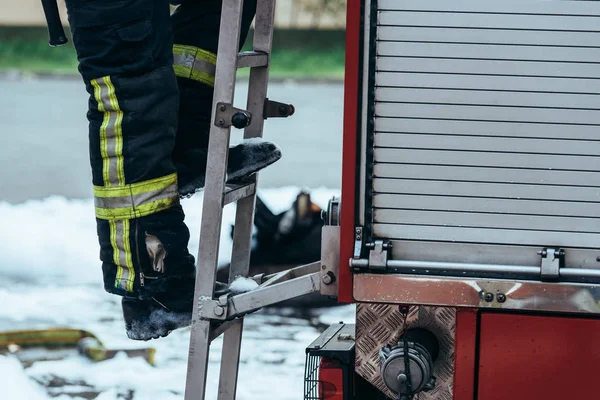 Plan Recadré Pompier Uniforme Protection Debout Sur Une Échelle Camion — Photo gratuite