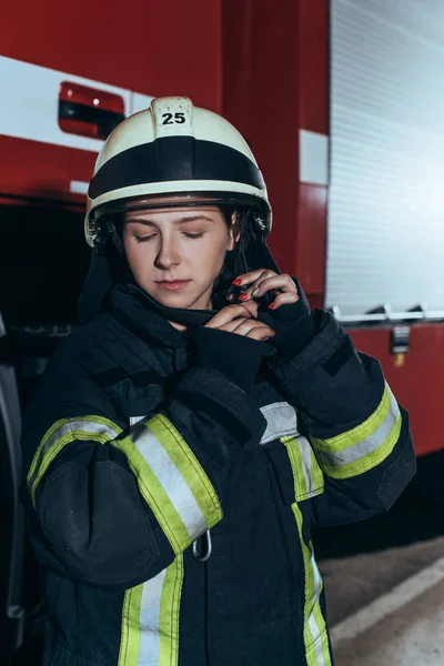 Portret Kobiet Strażak Mundurze Sprawdzanie Kask Straży Pożarnej — Darmowe zdjęcie stockowe