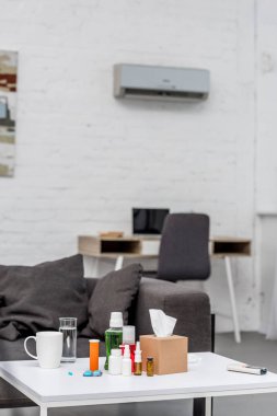 Tablo arka plan üzerinde çalışma alanı ile oturma odasında çeşitli ilaçlar ile