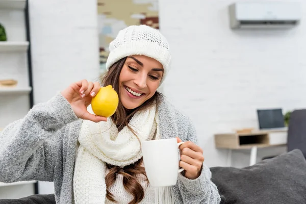 Smiling Young Woman Warm Clothes Holding Lemon Cup Tea Home — Free Stock Photo