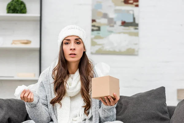 Mujer Joven Enferma Ropa Abrigo Sentada Sofá Casa Sosteniendo Caja —  Fotos de Stock