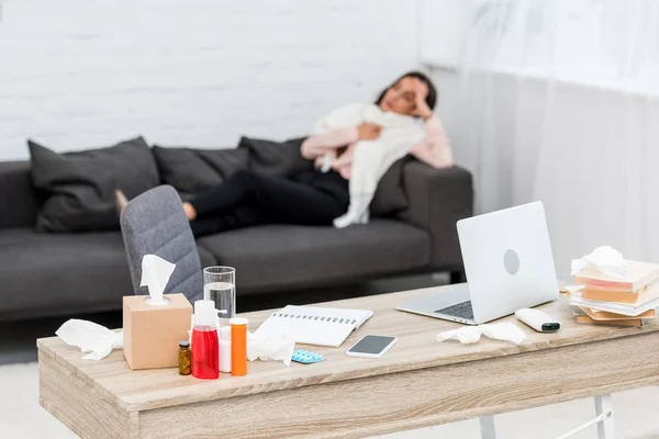 Kranke Junge Frau Auf Sofa Liegend Mit Arbeitstisch Voller Medikamente — Stockfoto