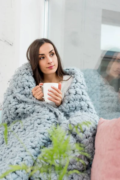 Beautiful Young Woman Sitting Windowsill Covered Blanket Cup Warming Drink — Stock Photo, Image