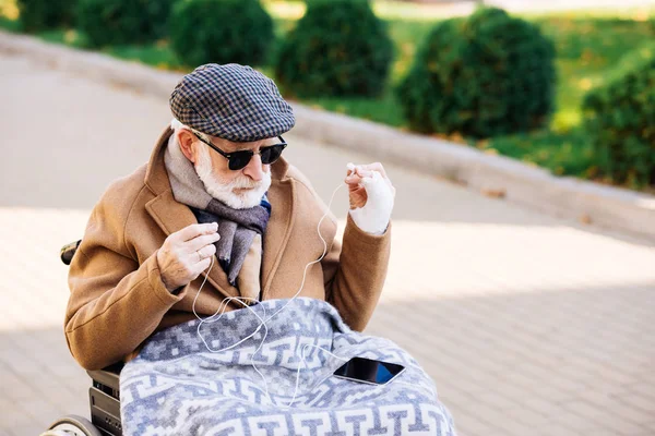 Hombre Discapacitado Senior Silla Ruedas Con Teléfono Inteligente Auriculares Calle — Foto de stock gratis