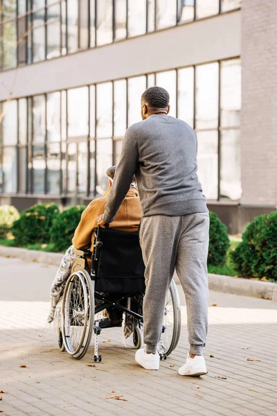 Visão Traseira Idoso Com Deficiência Cadeira Rodas Com Xadrez Cuidador — Fotografia de Stock