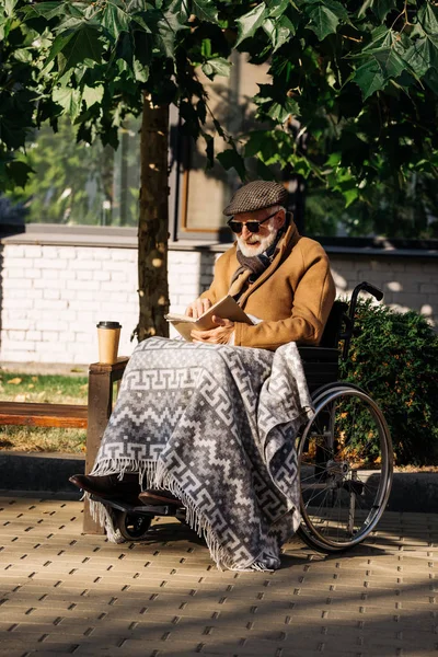 Kıdemli Adam Tekerlekli Sandalyeye Mahkum Ile Kağıt Bardak Kahve Okuma — Ücretsiz Stok Fotoğraf