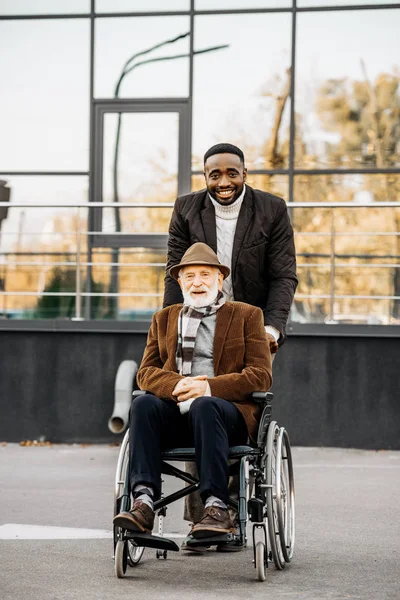 Ανώτερος Απενεργοποιημένη Άνδρα Αναπηρικό Καροτσάκι Και Αφρικανική Αμερικανική Άνθρωπος Ιππασίας — Φωτογραφία Αρχείου