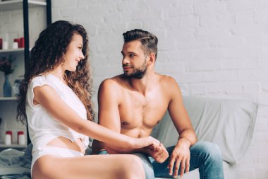 Beyaz külot evde yatak odasında erkek arkadaşının elini tutarak neşeli seksi kız