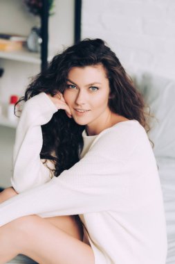 gülümseyen kıvırcık kadın kamera evde yatakta bakarak yüksek açılı görünüş