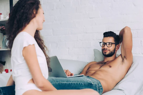 Cheerful Shirtless Male Freelancer Eyeglasses Working Laptop Talking Girlfriend Bedroom — Free Stock Photo