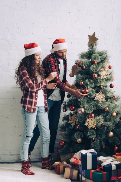 Couple Santa Hats Decorating Christmas Tree Home — Stock Photo, Image