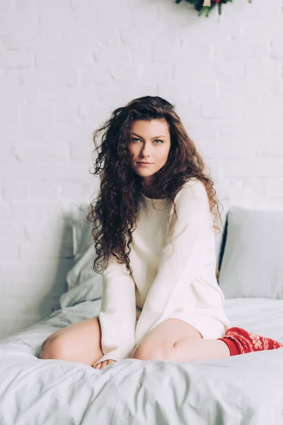 Krullend Verleidelijke Meisje Witte Trui Rode Wollen Sokken Zitten Bed — Stockfoto