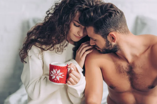 彼氏のそばに座って コーヒー カップを保持している巻き毛の女性のクローズ アップ表示 — ストック写真