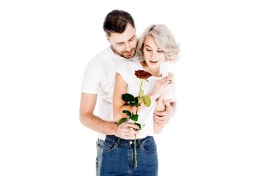 Beautiful couple with flower hugging while man giving to woman red flower isolated on white  clipart