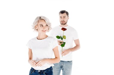 Beautiful smiling woman looking away while man holding flower isolated on white  clipart