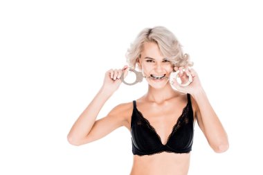 Attractive blonde young adult with handcuffs in mouth isolated on white  clipart