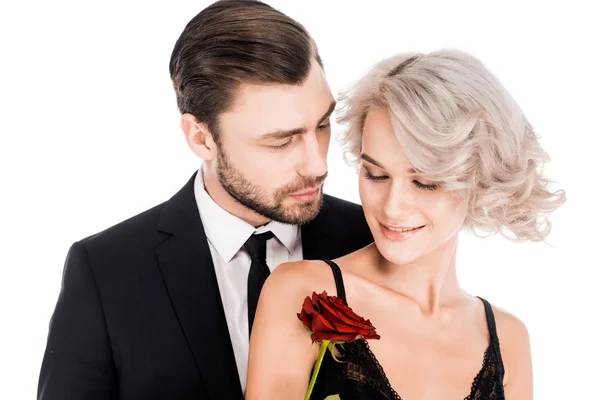 Fantastic couple standing together while woman holding flower isolated on white