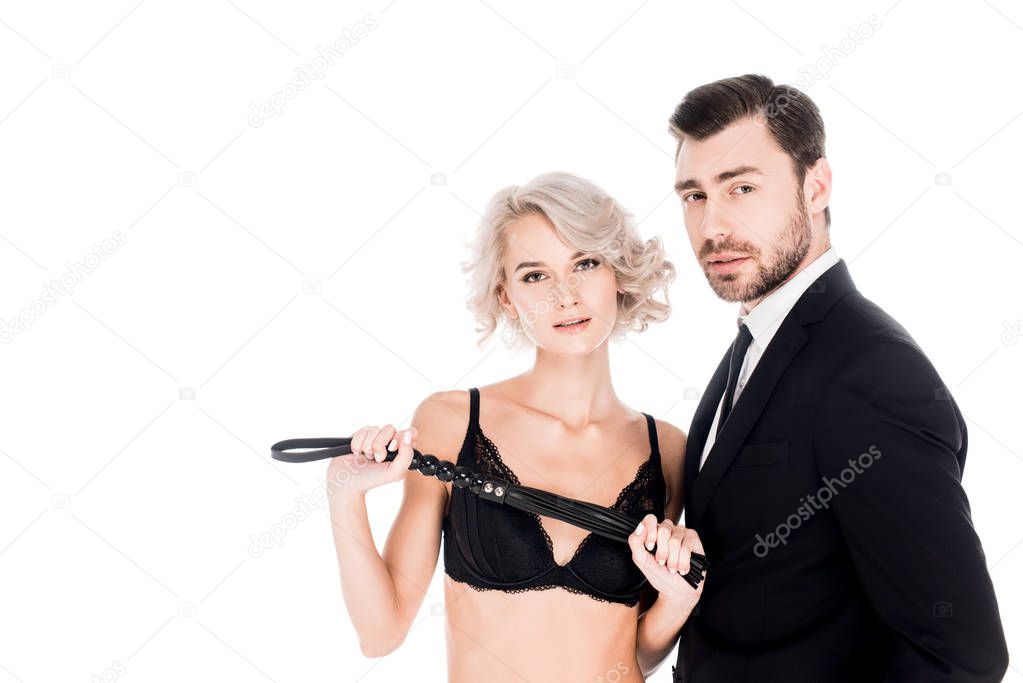 Beautiful couple of young adult with whip looking at camera isolated on white