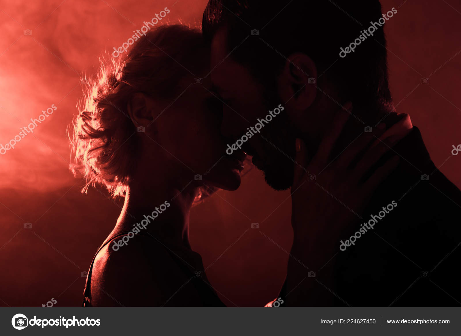 Intense close-up of passionate couple almost kissing in red smoky light – the spark of steamy sex scenes and sensual seduction
