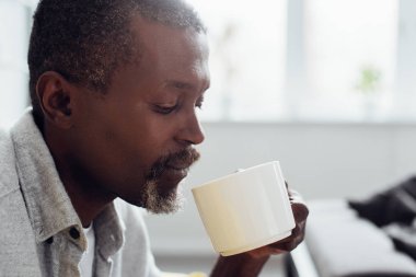 oturma odasında kahve içme olgun Afro-Amerikan adamın yakın çekim 