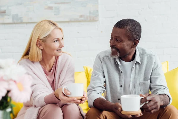 Smiling Mature Woman Sitting Sofa African American Man Drinking Coffee — Stock Photo, Image
