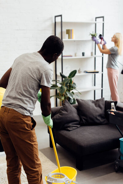 mature couple doing housecleaning in living room together