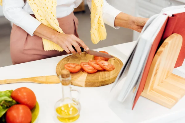 Close Woman Slicing Tomatoes Reading Recipe Cookbook Kitchen — Stock Photo, Image