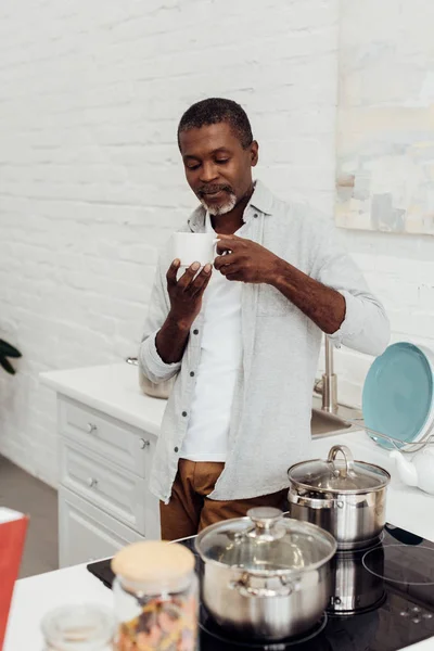 Africano Americano Maturo Uomo Tenendo Bianco Tazza Mentre Piedi Cucina — Foto Stock