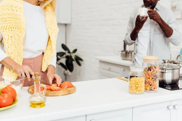 Beskuren Bild Mogen Blond Kvinna Matlagning Middag Medan Afrikanska Amerikansk — Stockfoto