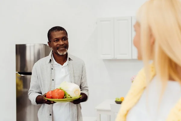 Afroamerikanska Mannen Håller Grönsaker Och Tittar Kvinna — Gratis stockfoto