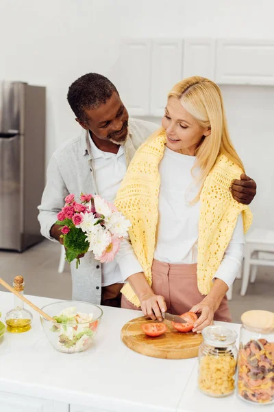 Handsome African American Husband Gifting Flowers Mature Blonde Wife Kitchen — Stock Photo, Image