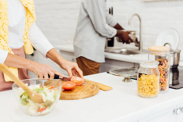cropped view of couple cooking dinner together at home