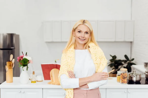 Lachende Blonde Vrouw Met Armen Gekruist Staande Keuken — Stockfoto