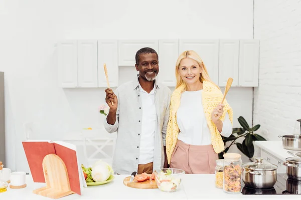 Alegre Pareja Interracial Sosteniendo Utensilios Cocina Juntos Cocina — Foto de Stock