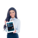 Piękna dziewczyna Afryki amerykański holding cyfrowego tabletu z aplikacji rezerwacji i uśmiecha się do kamery na białym tle