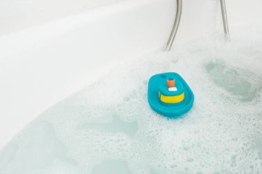 Beyaz küvet su ve banyo oyuncağı ile...