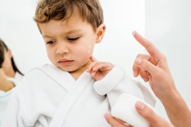 uygulanan yüz kremi yürümeye başlayan çocuk evlat yanağına Genç Anne