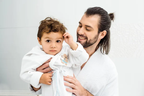 Papà Guardando Figlio Del Bambino Accappatoio Bianco Sorridente — Foto stock gratuita