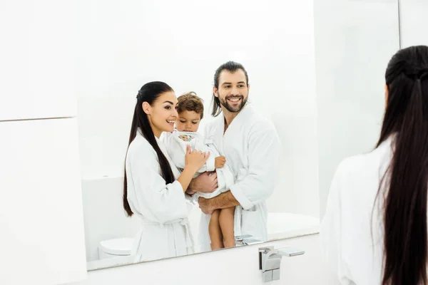 Mamá Papá Mirándose Espejo Sosteniendo Hijo Pequeño Con Batas Blancas — Foto de Stock