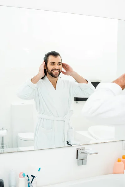 Hombre Guapo Mirando Espejo Sonriendo Baño Blanco —  Fotos de Stock