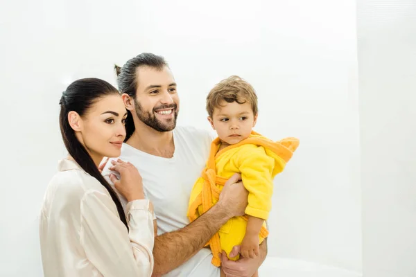 幸福的年轻家庭与可爱的儿子在黄色浴衣 — 免费的图库照片
