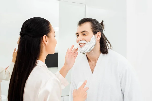 Hombre Guapo Sonriendo Mientras Que Mujer Que Aplica Espuma Afeitar — Foto de stock gratuita