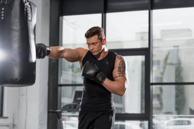 kum torbası içinde jimnastik salonu ile egzersiz yakışıklı kaslı boksör