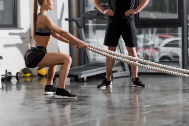 halatlar içinde jimnastik salonu ile çalışma dışarı atletik vücut geliştirmeci, izlerken Trainer kırpılmış görüntü