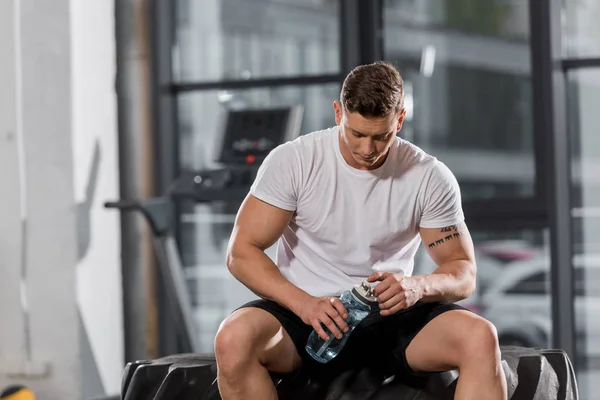 Handsome Athletic Bodybuilder Sitting Tire Sport Bottle Water Gym — Stock Photo, Image