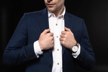 cropped shot of young businessman in stylish suit with wrist watch isolated on black clipart